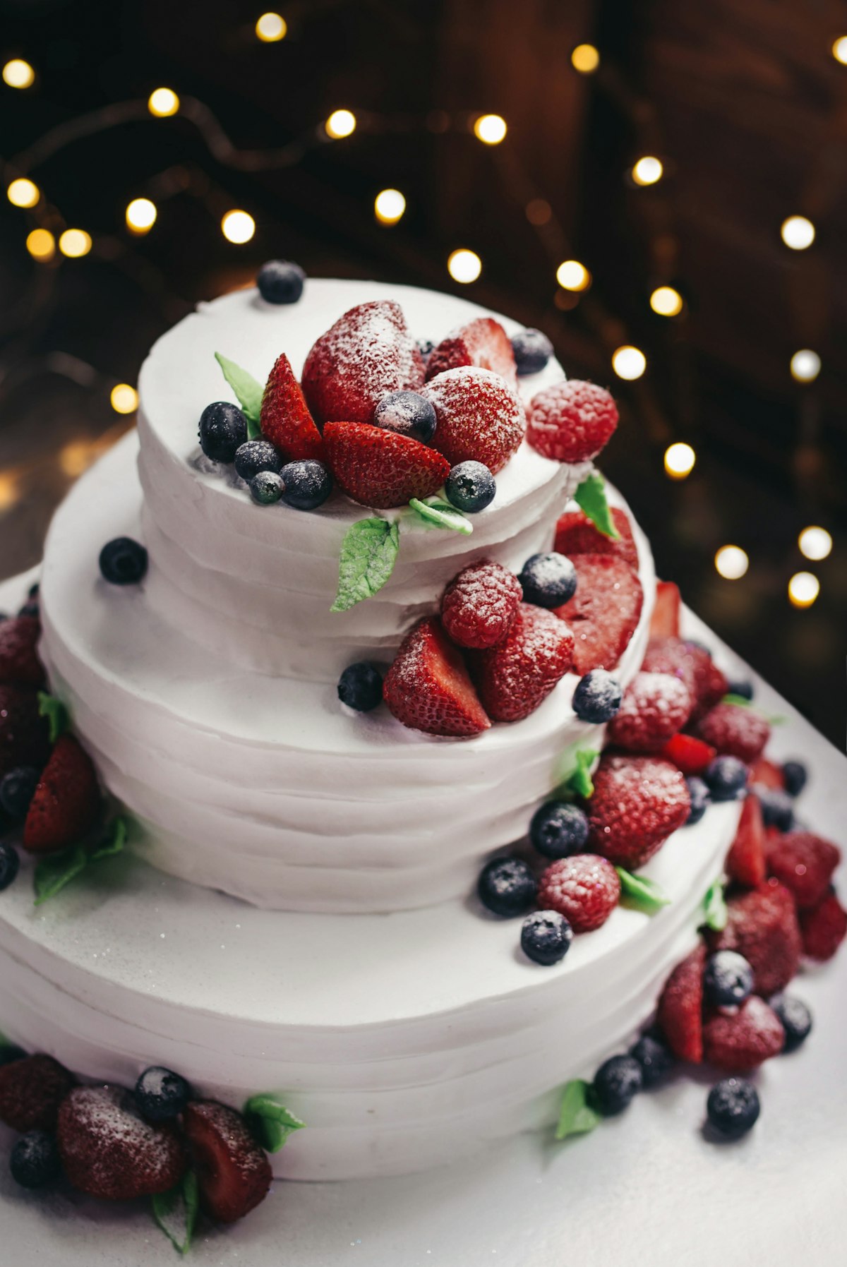 Three-tier custom cake with fresh berries — for weddings and quinceañeras